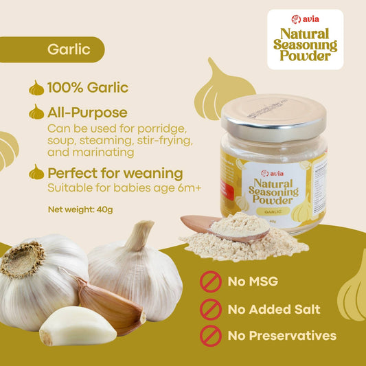 A jar of Avia Natural Seasoning Powder Garlic flavor shown on a beige and olive-green promotional graphic with garlic bulbs, loose powder, and text highlighting ingredients and benefits.